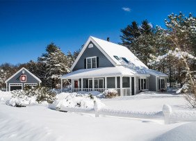 blue-house-with-white-trim-in-winter-snow-GettyImages-539306395-1300w-867h