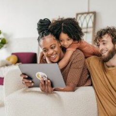 family-in-living-room-looking-at-a-tablet-gettyimages-1345741865-1300w-867h